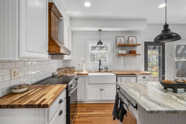 kitchen with open shelves, a sink, butcher block counters, decorative backsplash, and electric range oven