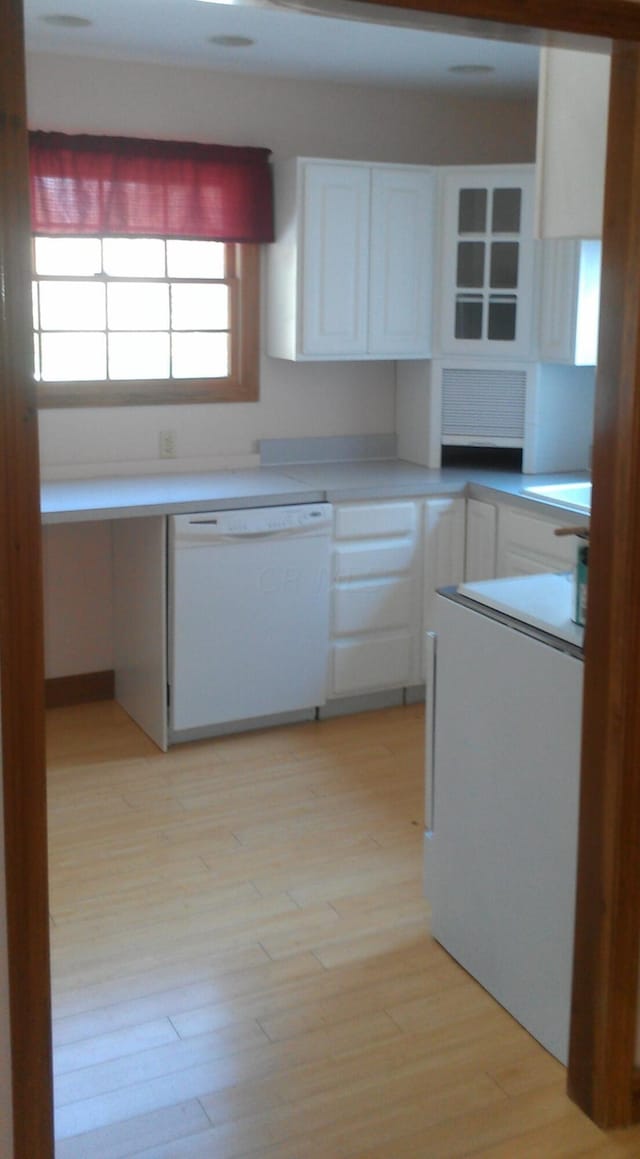 kitchen featuring white dishwasher, white cabinetry, and light hardwood / wood-style flooring