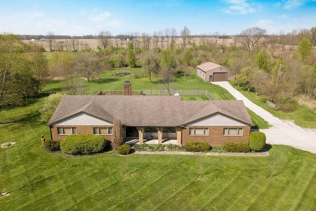 view of front of house with a front yard, a rural view, an outbuilding, and a garage