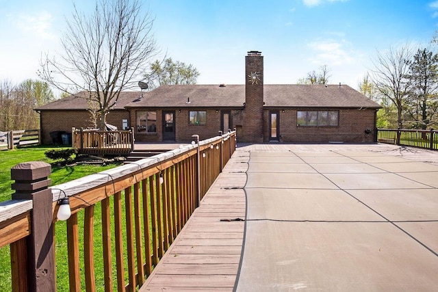 rear view of property with a lawn and a deck