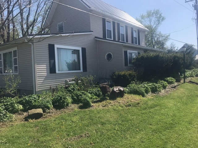 view of property exterior with a lawn