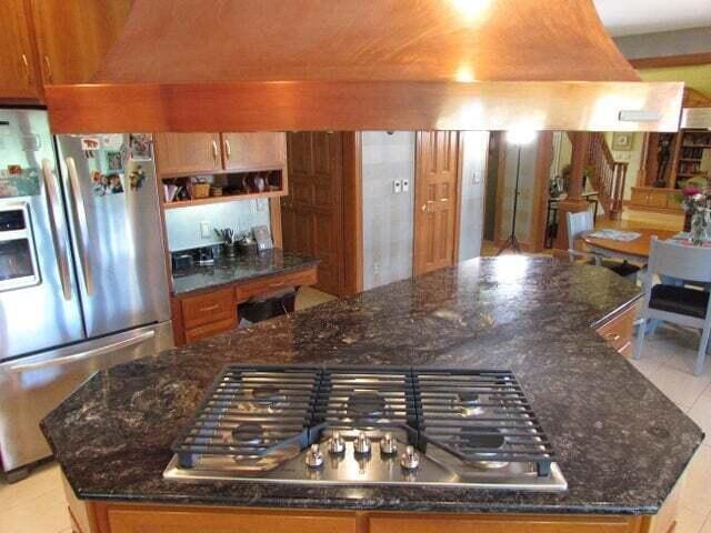 kitchen with appliances with stainless steel finishes, a center island, and dark stone counters