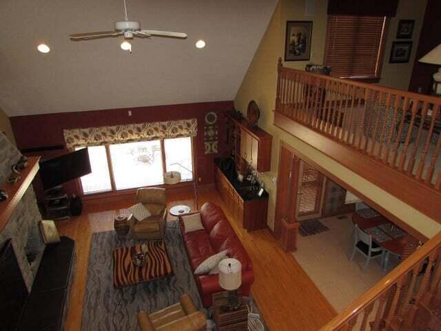 living room featuring ceiling fan, lofted ceiling, and hardwood / wood-style floors