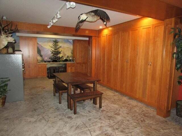 dining room featuring rail lighting and wood walls