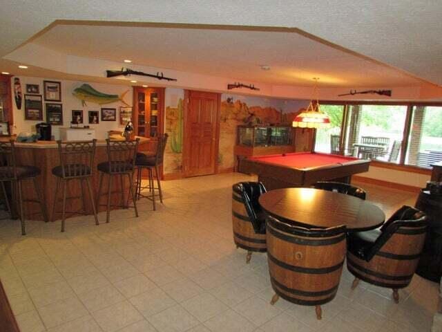 dining room with a textured ceiling, pool table, and bar