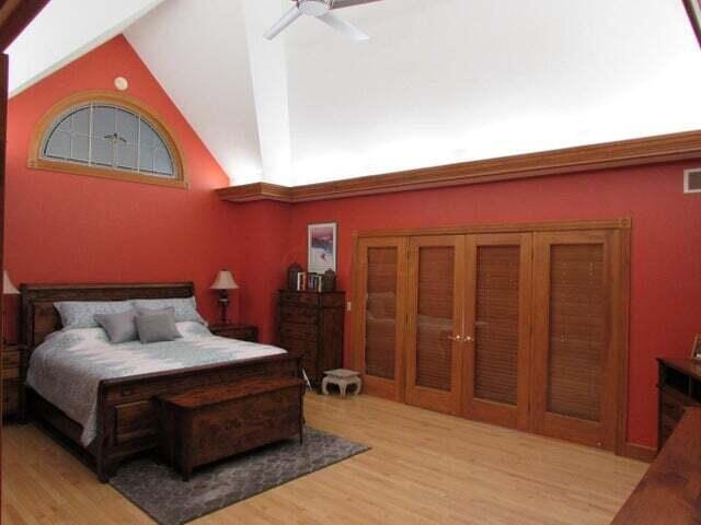 bedroom with ceiling fan, high vaulted ceiling, and light wood-type flooring