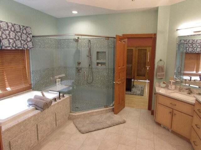 bathroom with plus walk in shower, tile patterned flooring, and vanity