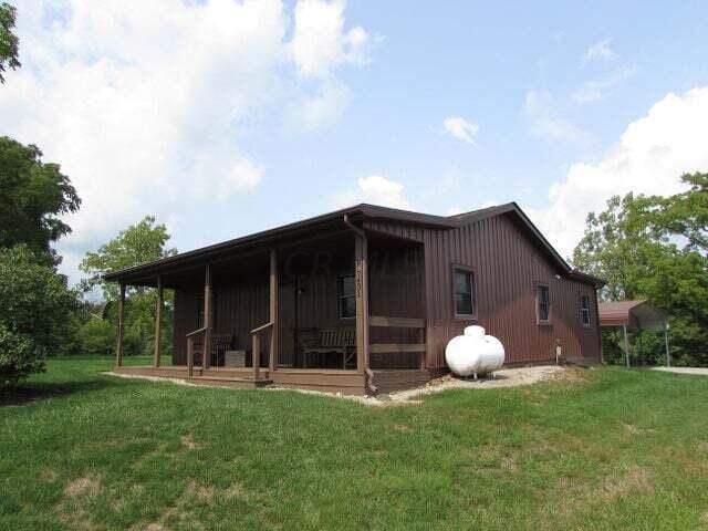 rear view of property featuring a yard and a porch