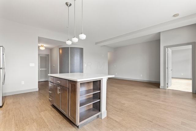 51 N High St Unit 506, Columbus, OH 43215 - kitchen with open shelves, light wood-style floors, light countertops, pendant lighting, and dark brown cabinetry