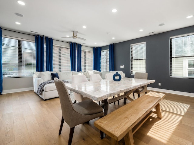 dining space with ceiling fan and light hardwood / wood-style flooring