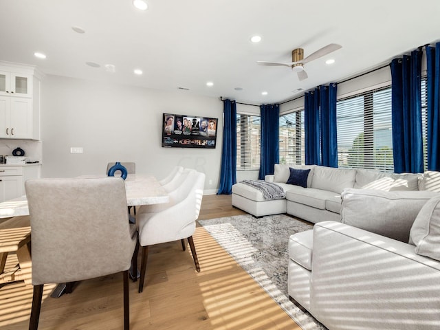 living room featuring light hardwood / wood-style flooring and ceiling fan