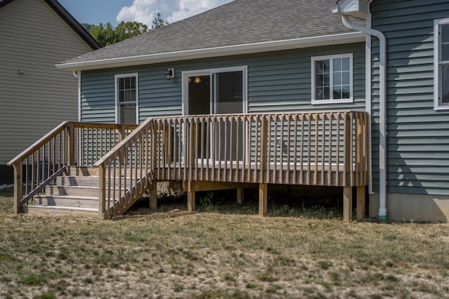 back of property with a yard and a wooden deck