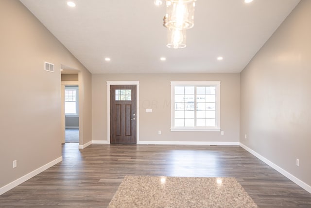 entrance foyer featuring lofted ceiling, plenty of natural light, and dark wood-type flooring