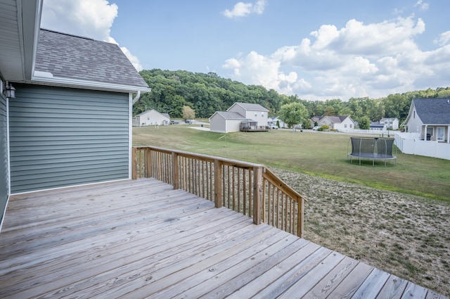 wooden deck featuring a lawn and a trampoline