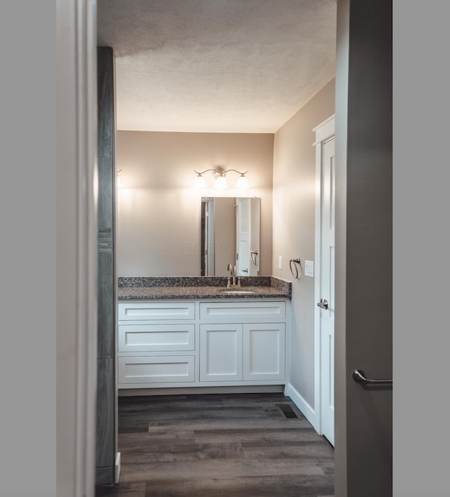 bathroom featuring hardwood / wood-style floors, vanity, and a textured ceiling