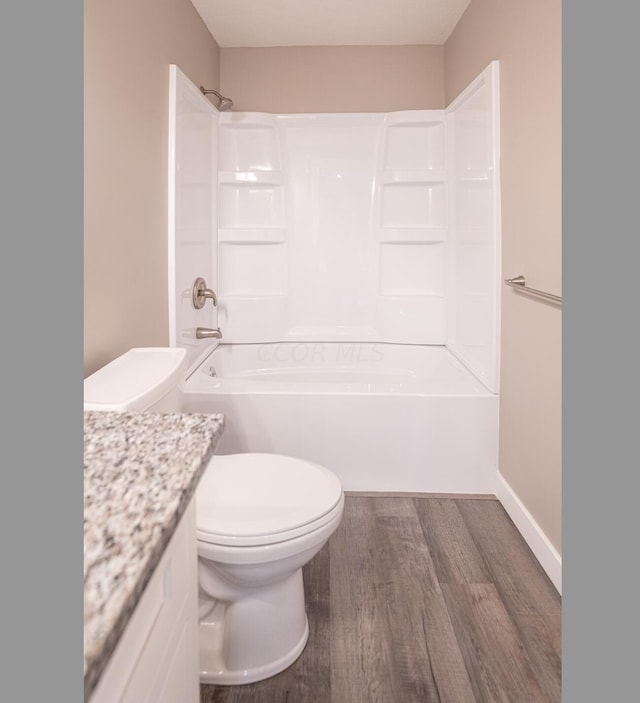 full bathroom with hardwood / wood-style floors, vanity, shower / bath combination, and toilet