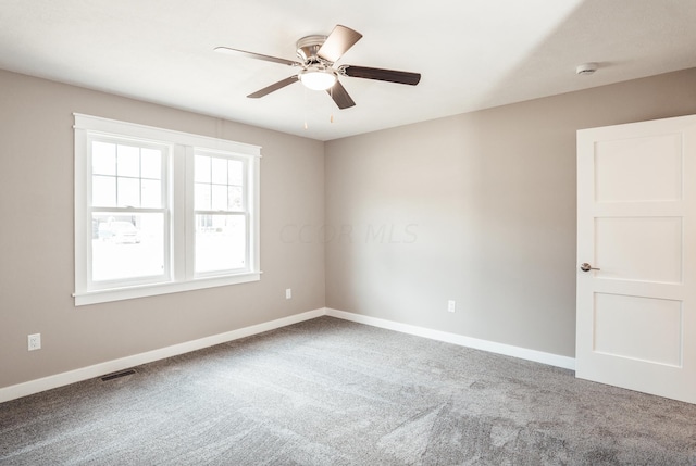 carpeted spare room with ceiling fan