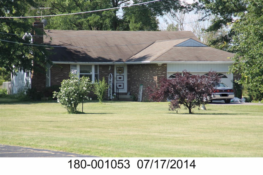 ranch-style home featuring a garage and a front yard