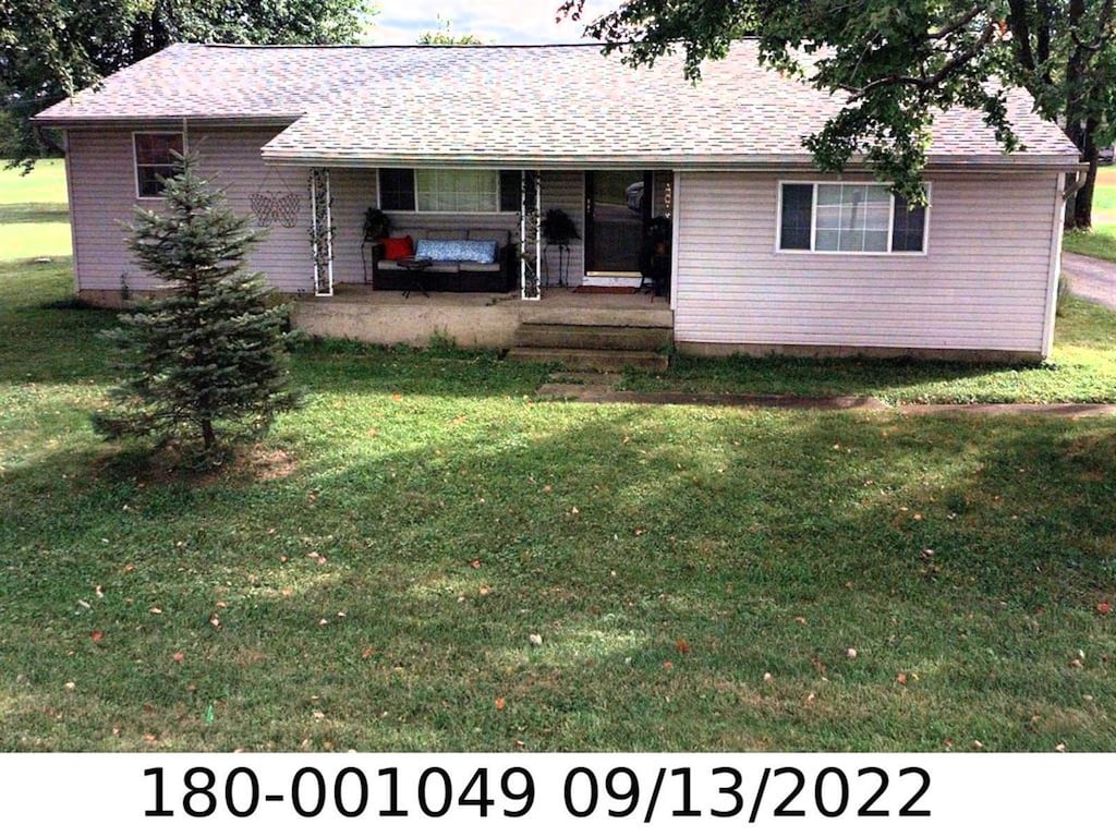 ranch-style home featuring a porch and a front lawn