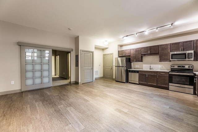 kitchen featuring dark brown cabinetry, sink, stainless steel appliances, track lighting, and light wood-type flooring