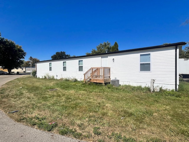 view of front of home featuring cooling unit and a front yard