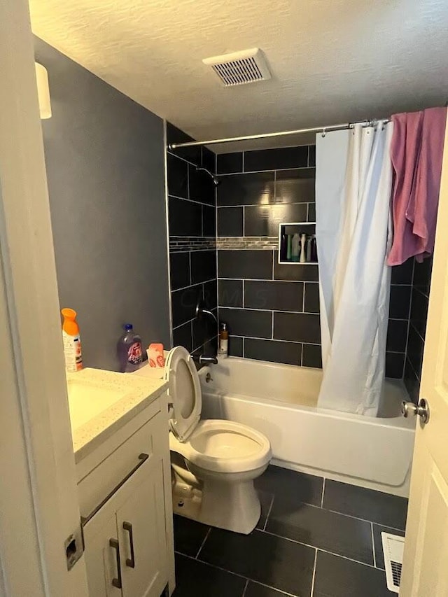 full bathroom featuring vanity, shower / bath combination with curtain, tile patterned flooring, toilet, and a textured ceiling