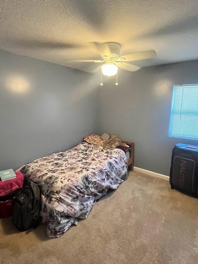 bedroom with light carpet, a textured ceiling, and ceiling fan