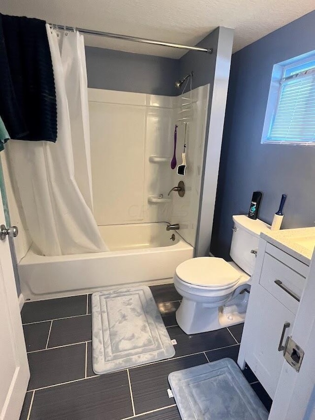 full bathroom with a textured ceiling, vanity, shower / bath combo, and toilet