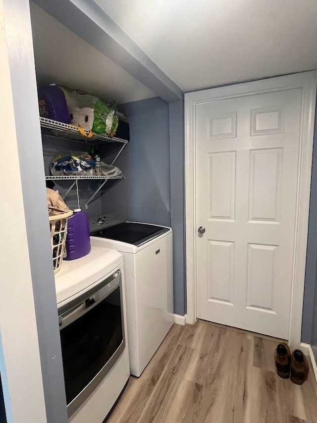 washroom with separate washer and dryer and light wood-type flooring