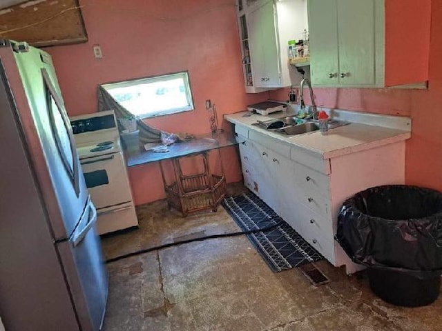 kitchen with stainless steel fridge, white stove, and sink