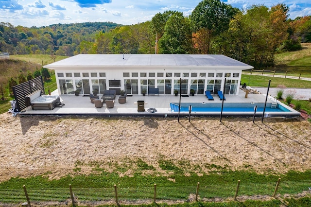 rear view of house featuring a fenced in pool, an outdoor living space, a patio, and a rural view