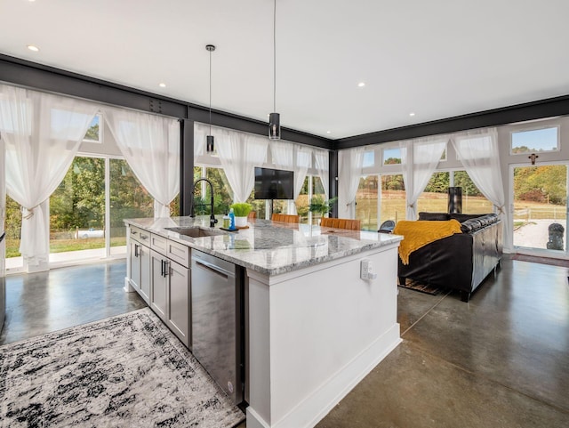 kitchen featuring light stone countertops, sink, stainless steel dishwasher, decorative light fixtures, and a center island with sink