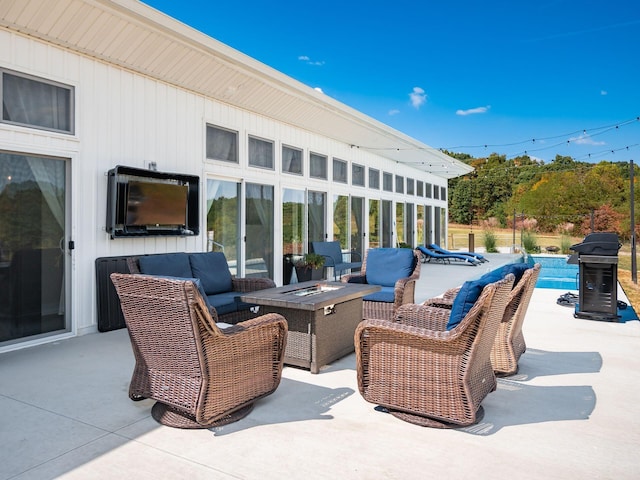 view of patio with grilling area and an outdoor living space with a fire pit