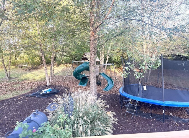 view of yard featuring a playground and a trampoline