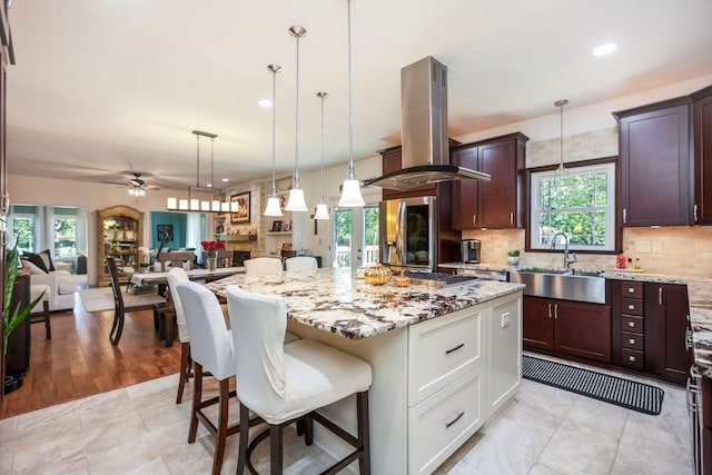 kitchen featuring plenty of natural light, a kitchen island, white cabinetry, and island exhaust hood