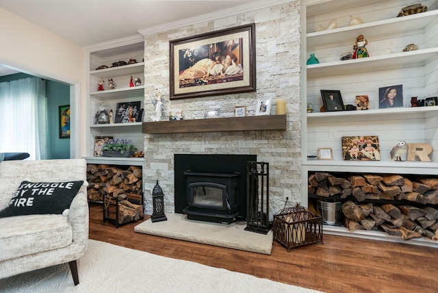 living room with dark hardwood / wood-style floors, built in features, crown molding, and a wood stove