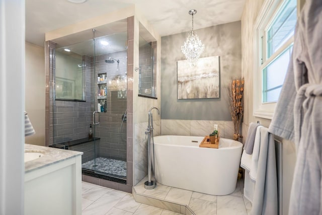 bathroom featuring vanity, separate shower and tub, and an inviting chandelier