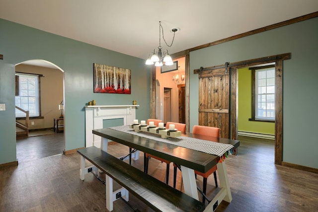 dining area with dark hardwood / wood-style flooring, crown molding, a barn door, a baseboard radiator, and an inviting chandelier