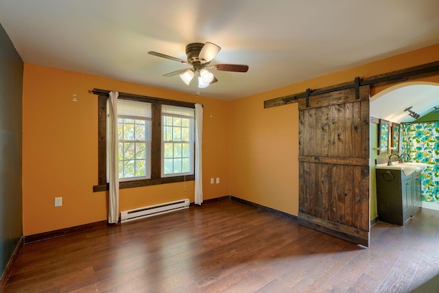 unfurnished room with ceiling fan, dark wood-type flooring, sink, a barn door, and a baseboard radiator