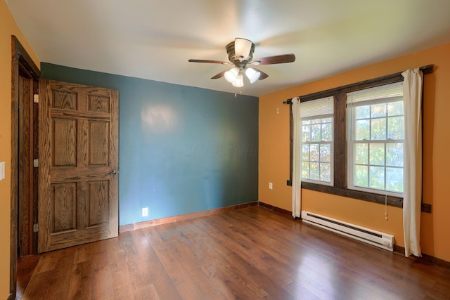 empty room with ceiling fan, baseboard heating, and dark wood-type flooring