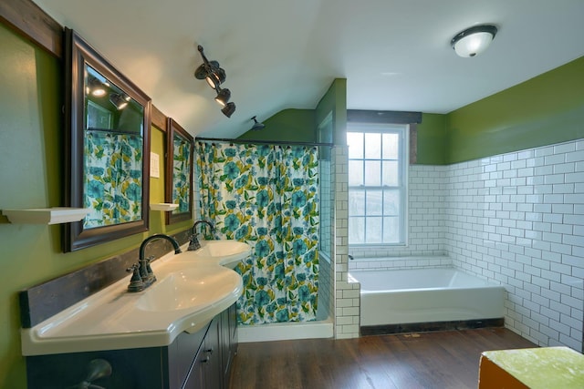 bathroom with plus walk in shower, hardwood / wood-style floors, vanity, and tile walls