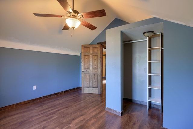 unfurnished bedroom featuring ceiling fan, lofted ceiling, dark wood-type flooring, and a closet