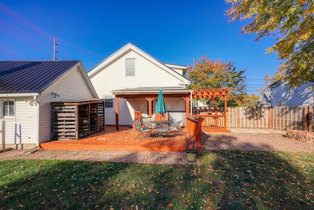 back of property with a pergola, a yard, and a deck