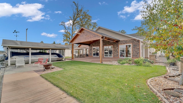 back of property featuring a lawn and a fire pit