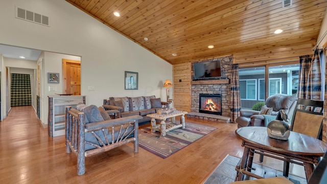 living room featuring wood ceiling, a fireplace, high vaulted ceiling, and light hardwood / wood-style floors