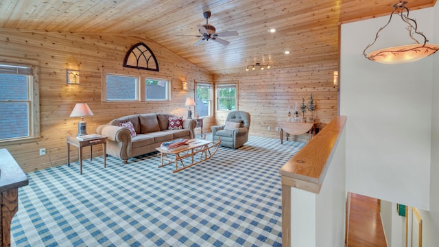 living room with wooden walls, high vaulted ceiling, wooden ceiling, and ceiling fan