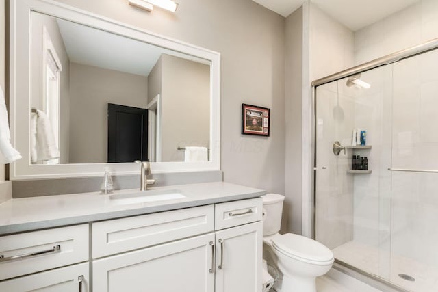 full bathroom with toilet, a stall shower, and vanity