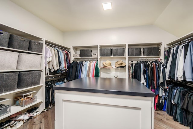 spacious closet featuring light wood-style flooring and vaulted ceiling