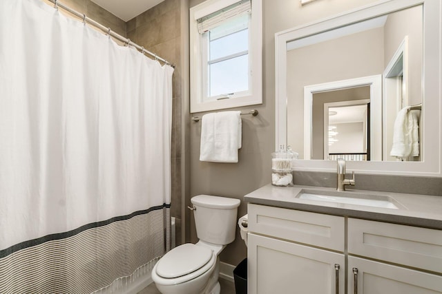 bathroom with curtained shower, vanity, and toilet