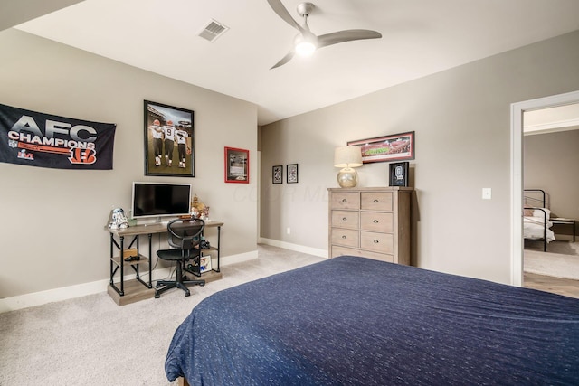 carpeted bedroom with visible vents, baseboards, and a ceiling fan
